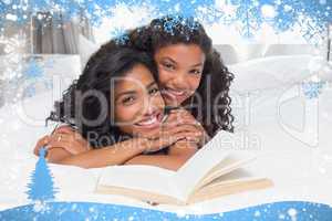 Mother and daughter reading book together on bed
