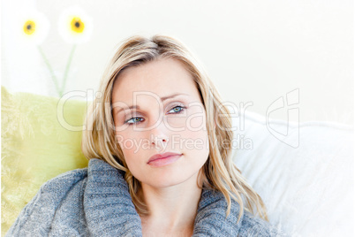 Exhausted woman lying on the sofa with a grey pullover