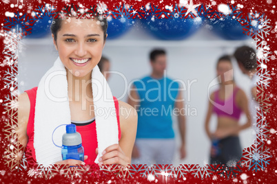 Female holding water bottle with fitness class in background