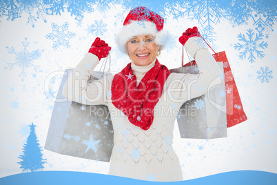 Festive woman smiling at camera holding shopping bags