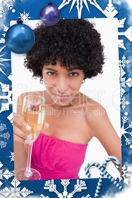Young woman holding a glass of champagne while looking at the camera