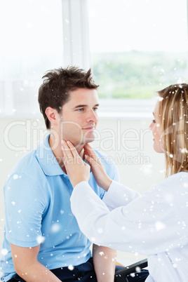 Female doctor examinating the throat of a happy patient sitting