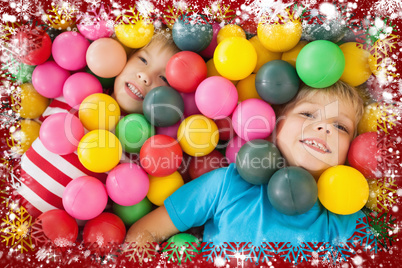 Composite image of happy children playing in ball pool