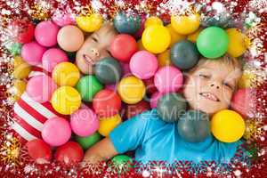 Composite image of happy children playing in ball pool