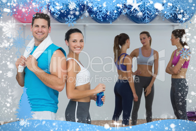 Smiling couple with fitness class in background