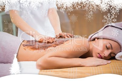 Attractive woman receiving chocolate back mask at spa center