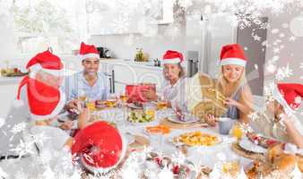 Composite image of smiling family around the dinner table at chr