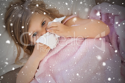 Composite image of girl suffering from cold as she lies in bed