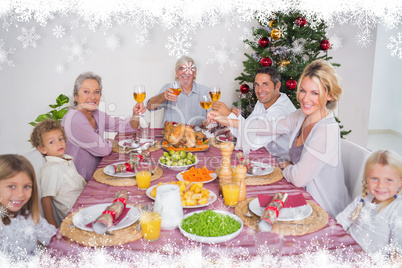 Composite image of family raising their glasses at christmas
