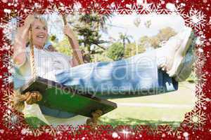 Composite image of mature couple at swing in the park