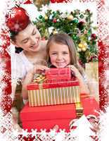 Mother and daughter at home holding a christmas gift