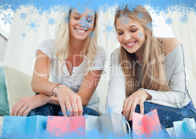 Smiling girls looking into the bags below them