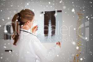 Gorgeous doctor with a stethoscope looking at a xray