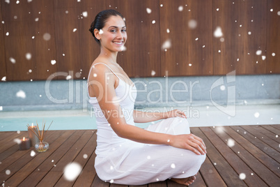 Content brunette in white sitting in lotus pose