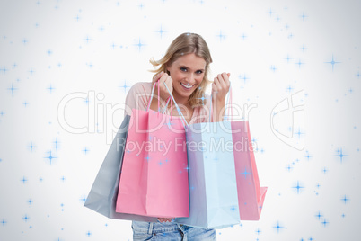 A smiling woman is carrying shopping bags