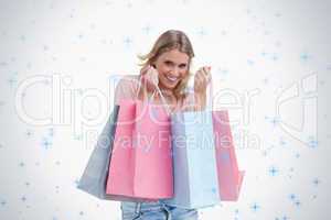 A smiling woman is carrying shopping bags