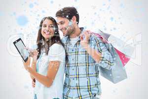 Composite image of attractive young couple with shopping bags an