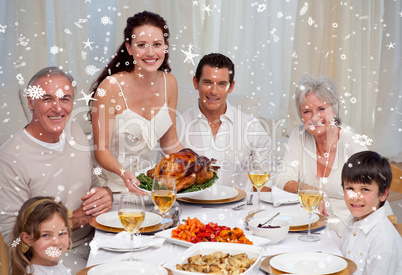 Composite image of family eating turkey in a dinner