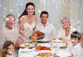Composite image of family eating turkey in a dinner