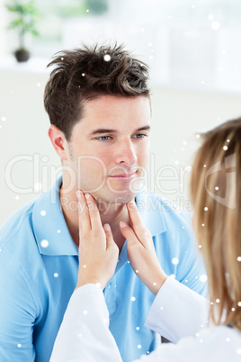 Female doctor touching the throat of a patient in the office