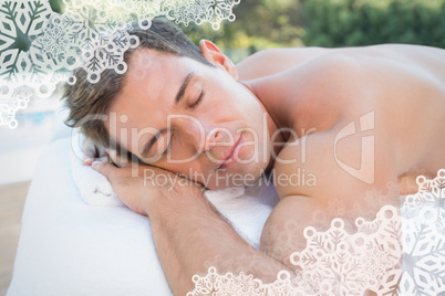 Peaceful man lying on massage table poolside