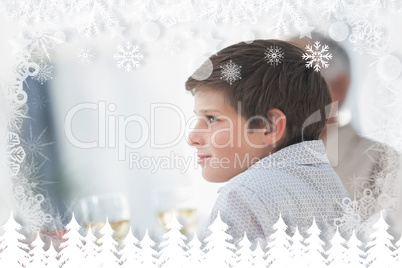 Composite image of side view of a little boy at table