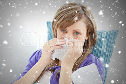 Portrait of a sick pretty woman blowing lying on a sofa