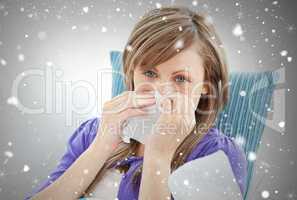 Portrait of a sick pretty woman blowing lying on a sofa