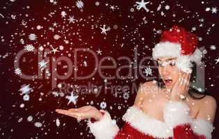 Surprised brunette in santa outfit presenting with hand