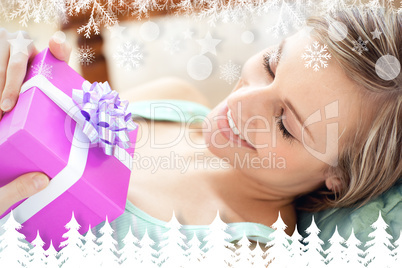 Composite image of happy woman holding a present Composite image of happy woman holding a present