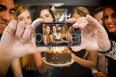 Composite image of hand holding smartphone showing