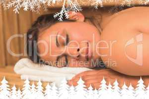 Smiling brunette lying down in a sauna