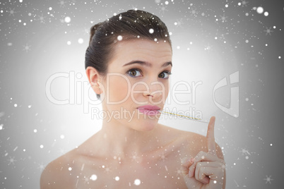 Upset natural brown haired model using a thermometer