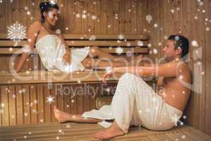 Happy couple relaxing in a sauna and chatting