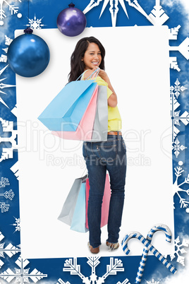 Rear view of a beautiful woman student with shopping bags