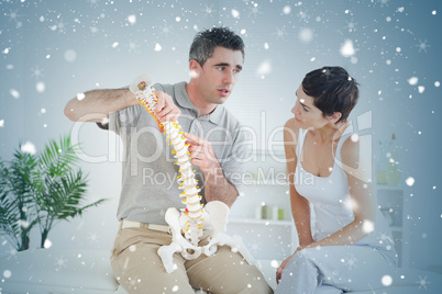 Brunette woman looking at a model spine