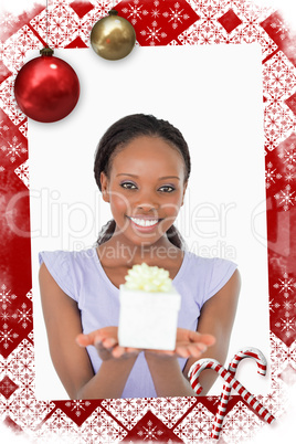 Smiling woman holding a present against a white background