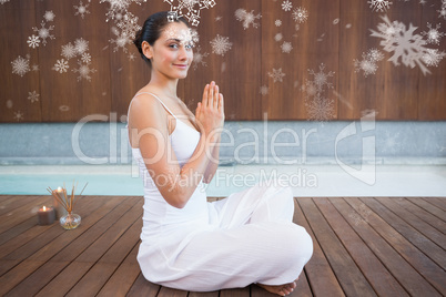 Content brunette in white sitting in lotus pose smiling at camera