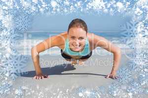 Composite image of fit woman in plank position on the beach