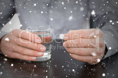 Mid section of a man holding glass of water and pill