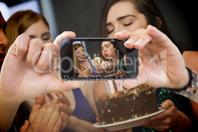 Composite image of hand holding smartphone showing