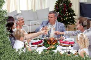 Family tusting in a christmas dinner with champagne