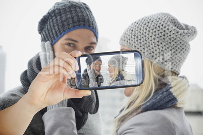 Composite image of hand holding smartphone showing