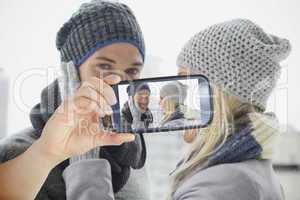 Composite image of hand holding smartphone showing