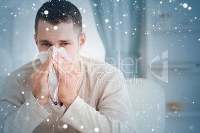 Composite image of young man blowing his nose