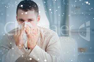 Composite image of young man blowing his nose