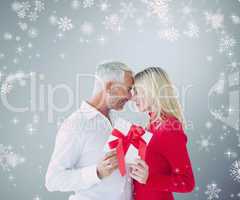 Composite image of loving couple with gift