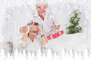 Composite image of old man hiding eyes of his wife for a gift