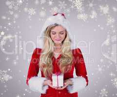 Composite image of pretty girl in santa outfit holding gift