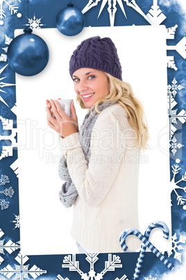 Composite image of pretty blonde in winter fashion holding mug